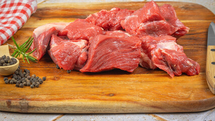 morceaux de boeuf cru, en gros plan, sur une planche à découper