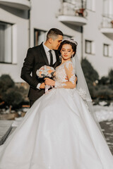 Naklejka premium Wedding couple in love. A beautiful bride and an elegant groom tenderly embrace and enjoy the day. A stylish couple of newlyweds. Concept of marriage