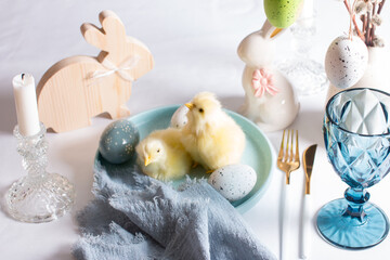 Easter table setting, yellow chickens, painted eggs. Easter willow in a vase