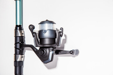 close-up of fishing reel with fishing rod on a white background isolated. Top view. Copy space.