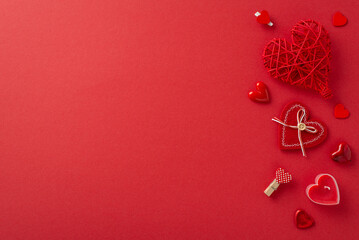 Valentine's Day festivity unfolds from above, showcasing artistic touches like adorned clothespins, flickering candle, wicker heart against a red canvas. Perfect for text or promotions