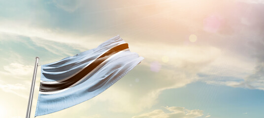 Botswana national flag cloth fabric waving on the sky - Image