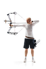 Full-length of serious man, archery sportsman aiming archery bow on target isolated over white...