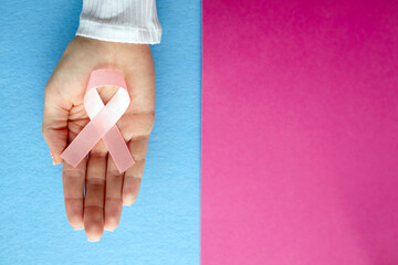 Pink cancer awareness ribbon with trail on blue background. concept of health and medicine