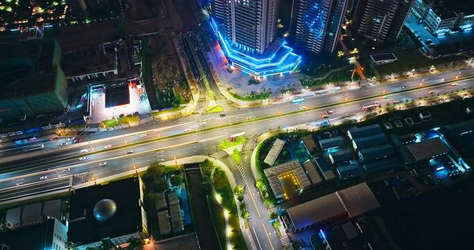 Aerial tilt down shot of city intersection with car traffic at night