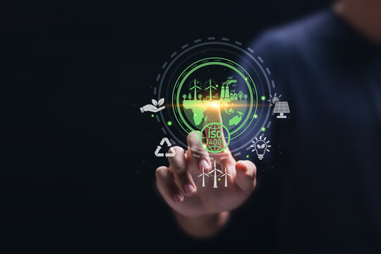 ISO 14001 concept. Businessman touch virtual icon of ISO 14001 certified for environmental management systems (EMS). Identify, control and reduce the environmental impact of activities.