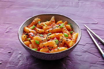 Tteokbokki or topokki, Korean street food, spicy rice cakes in red pepper gochujang sauce, a popular dish, with chopsticks