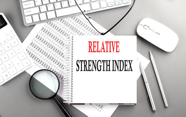 Relative Strength Index text on notebook with clipboard and calculator on a chart background - Powered by Adobe