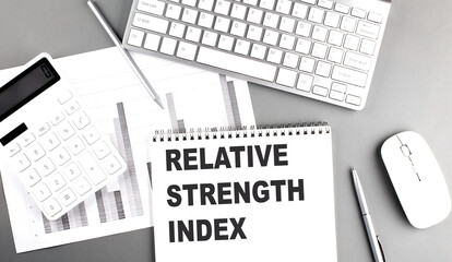 Relative Strength Index text on notebook with calculator , chart and keyboard business concept