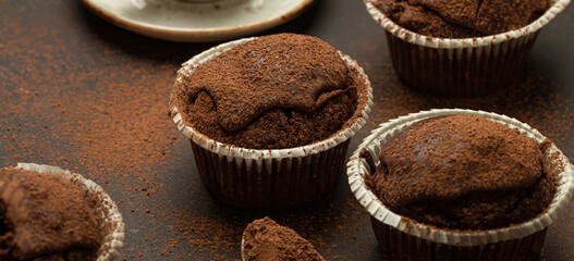 Chocolate and cocoa browny muffins with coffee cappuccino in cup angle view on brown rustic stone...