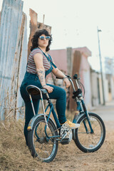 Mujer moda vintage junto a su bicicleta en la calle