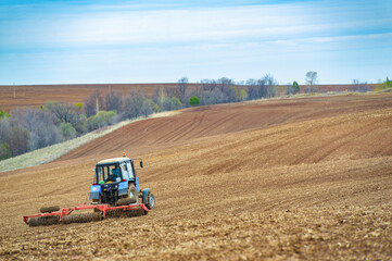 small blue tractor plowing the ground Let's bring life back to earth! Watch as this little blue tractor fearlessly plows the field, preparing it for a great harvest. Preparing for the field