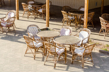 wooden chairs and round tables in an empty hotel cafe in Egypt Dahab South Sinai