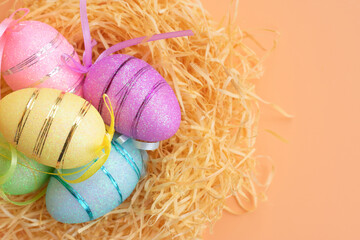 Easter party background with multi colored different eggs in yellow, pink, green, blue colors lying in nest.Copy space backdrop