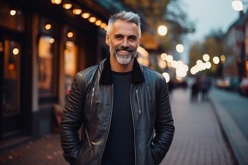 Portrait of a handsome middle-aged man smiling at the camera in the city