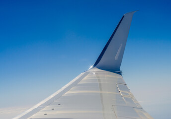 wing of the flying plane on a background of blue sky