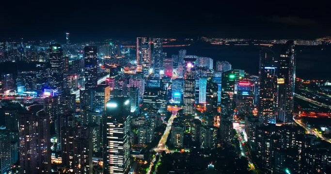 Aerial panning shot of Shenzhen financial district skyscraper buildings at night