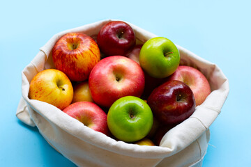 Variety of fresh apples on blue background.