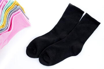 Black socks with colorful socks on white background.
