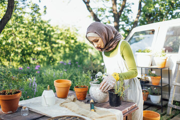 Muslim young attractive gardener at work, take care of green plants