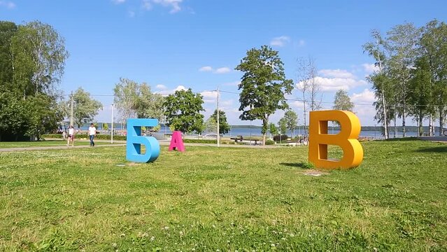 Russian language letters layout is located on the green grass in summer
