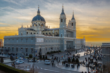 Madrid, Spain 28-12-2022 The Almudena Cathedral during a colorful sunset, it is the most important  and Catholic religious building in Madrid and a visit is free of charge except for the crypt   - obrazy, fototapety, plakaty
