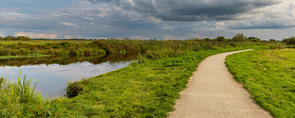 Dutch landscape with cycling road along nature park De Onlanden near Groningen city in The Netherlands