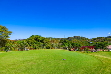 Fototapeta na wymiar 雄大な青空のゴルフ場・ロングコースのティーイングエリアのスタート地点の風景（神奈川県湯河原町）