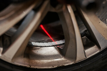 Close up of a laser balancing car wheel.