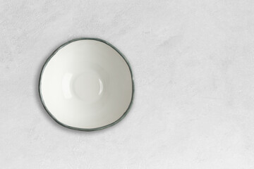 Obraz na płótnie Canvas Handmade empty ceramic plate top view with copy space on grey concrete table. Minimalism. Eco friendly ceramics handcraft tableware.