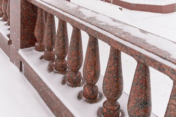 Vitebsk, Belarus, January 5, 2024. Fragment of the red granite fence of the park.                            