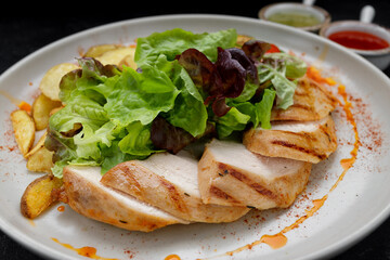 Fried chicken breast with grilled vegetables, mixed greens and potatoes