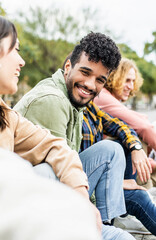 Vertical photo. Diverse group of young people laughing together. Hispanic latin man smiling at...