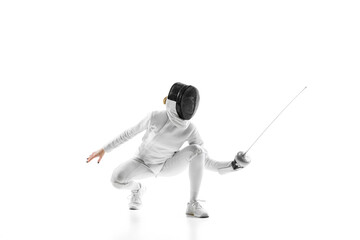Young girl, fencer, sportsman squats with sword, dodging opponent during fight against white studio...