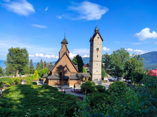 Old wooden Vang stave church with stone tower in summer. Karkonosze mountains, Karpacz, Poland