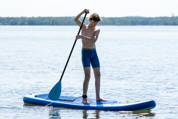 Teenager and SUP board. Active recreation on the Senftenberg lake. Federal land of Brandenburg. Germany.