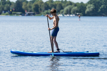 Teenager and SUP board. Active recreation on the Senftenberg lake. Federal land of Brandenburg. Germany.