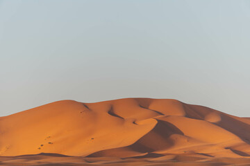 Fototapeta na wymiar minimalist look of big sand dunes in the desert morocco with orange color view 