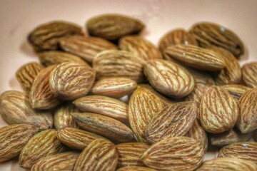 Fototapeta premium Closeup of a pile of almonds on a beige background.
