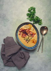 Pumpkin cream soup, curry, fried bacon, bruschetta chips,micro-greens, top view, no people,