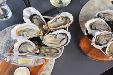 Fresh oysters with lemon on a plate - obrazy, fototapety, plakaty