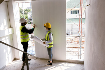 Engineers and Architect Caucasian looking at blueprint of building construction, planning the work in a professional. inspector is looking at steel structure and materials at construction site.