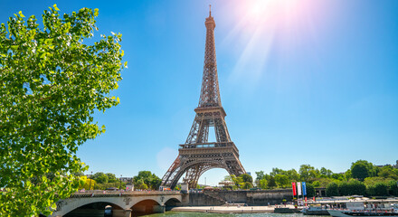 Paris street with view on the famous paris eiffel tower on a sunny day with some sunshine - 705054325