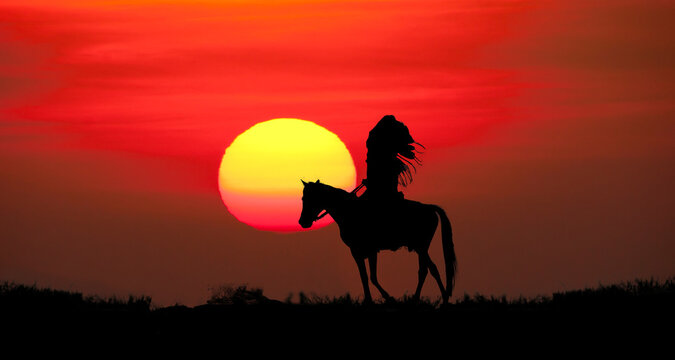 silhouette of indians man riding a horse on sunset background