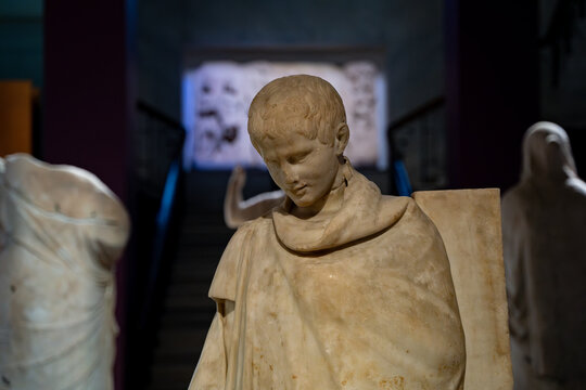 Marble statue of Ephebos in the Istanbul Archaeological Museums building. Istanbul, Turkey - December 23, 2023.