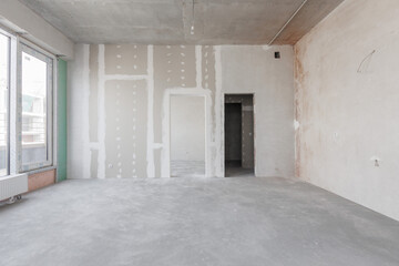 Obraz premium interior of the apartment without decoration in gray colors. rough finish