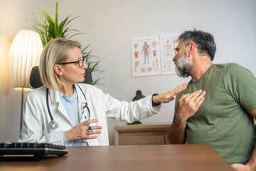 Mature man showing chest pain to doctor