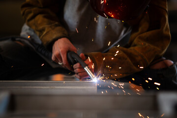Skilled professional welder technician welding a steel and iron in factory. Heavy industry duty...