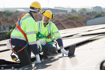 Professional electric engineers survey and inspect solar panels installation on the factory metal...