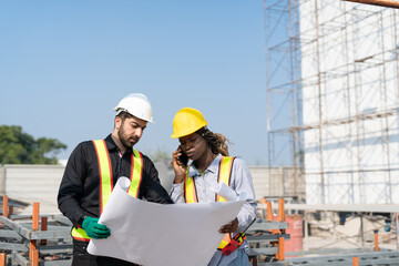 Fototapeta premium Civil engineer and architect with blueprint discussing inspecting structure building project at construction site.